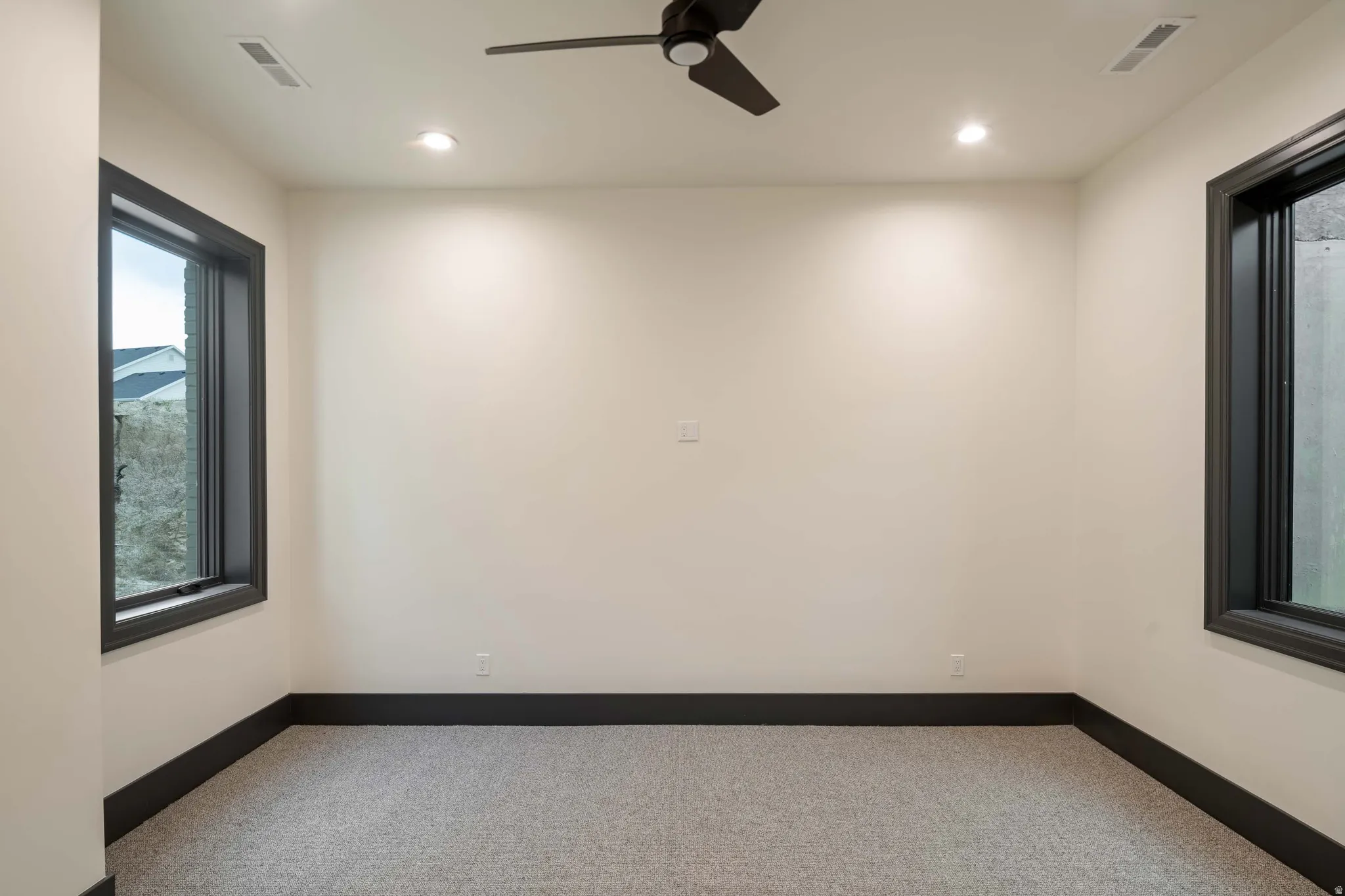 Bedroom featuring light-toned walls, dark trim, and light gray carpeting