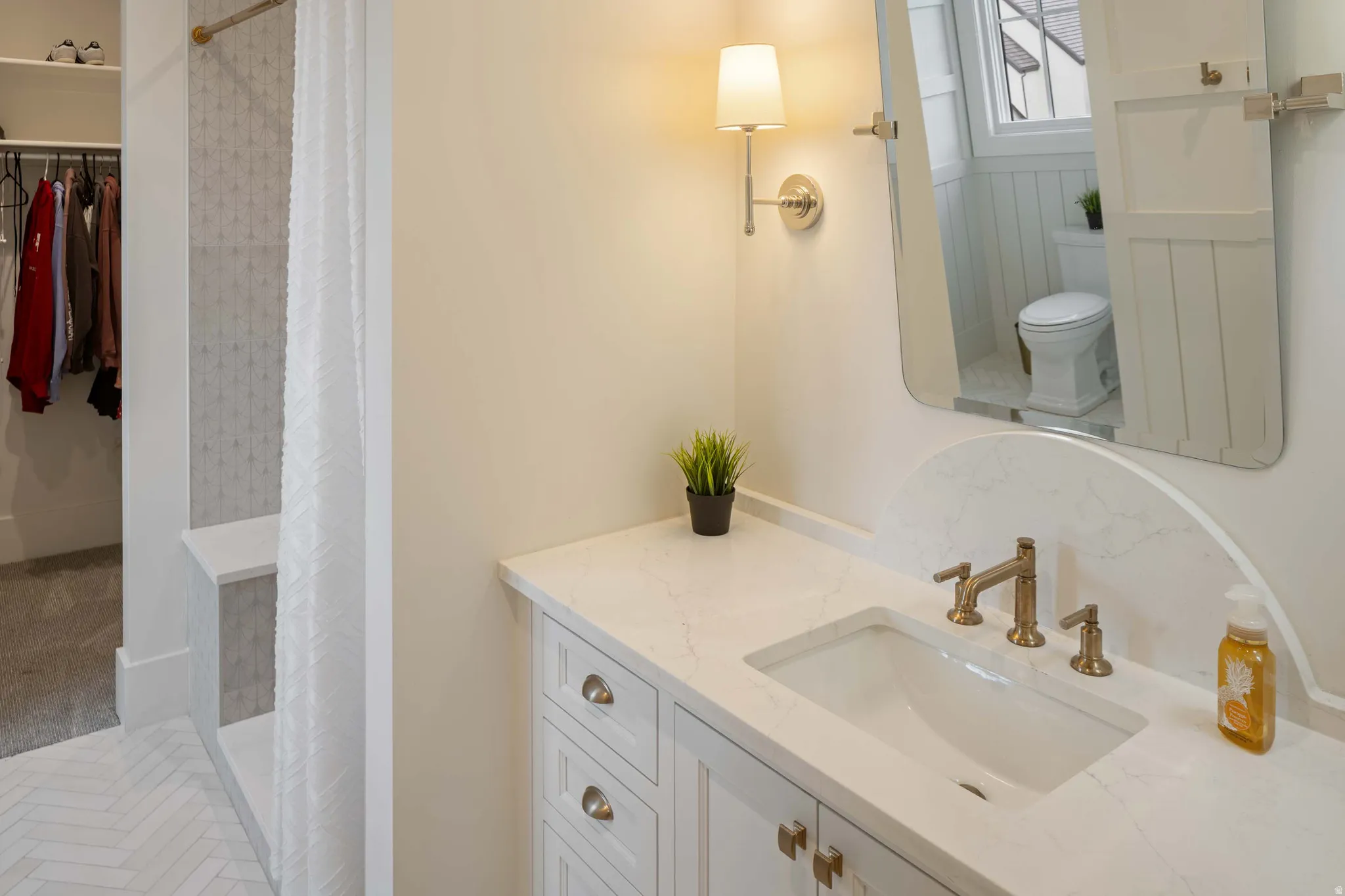 White vanity with integrated sink, bronze-finish faucet, and coordinating hardware