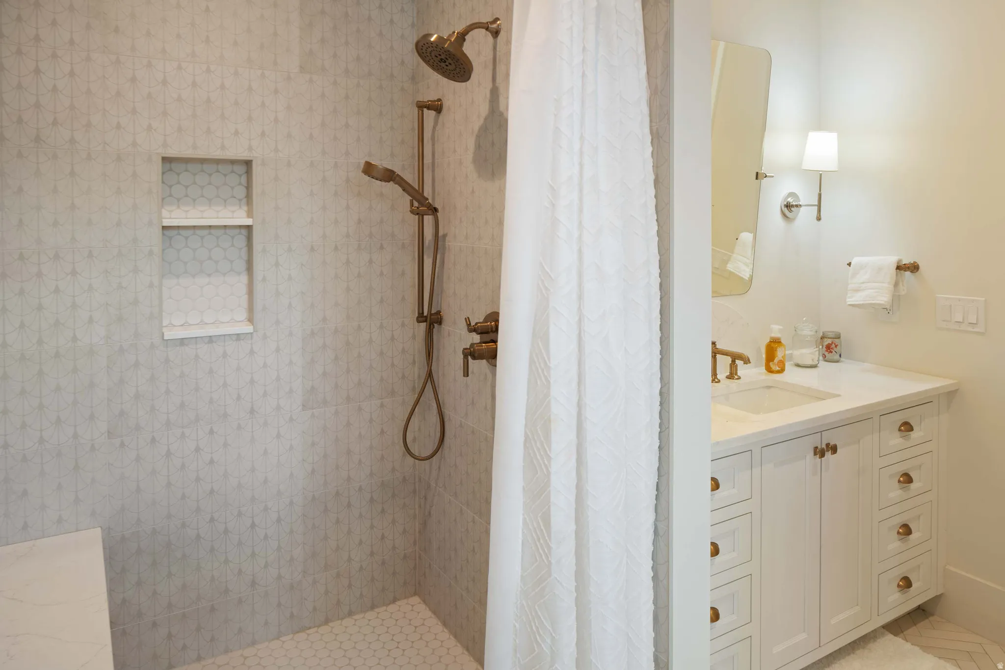 Bathroom featuring a walk-in shower with textured wall tile and a built-in niche