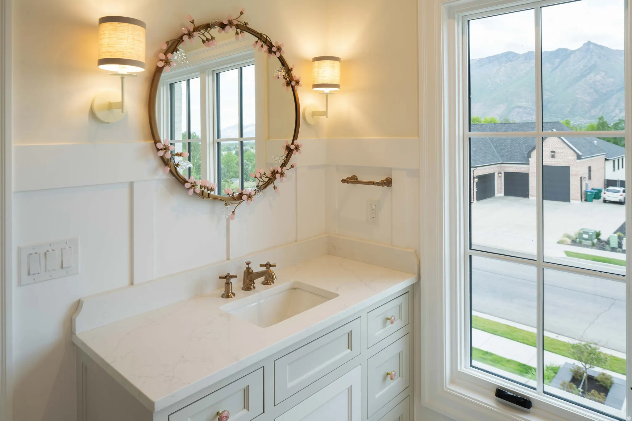 Bathroom vanity featuring a light-colored countertop, integrated sink, and bronze-finish faucet