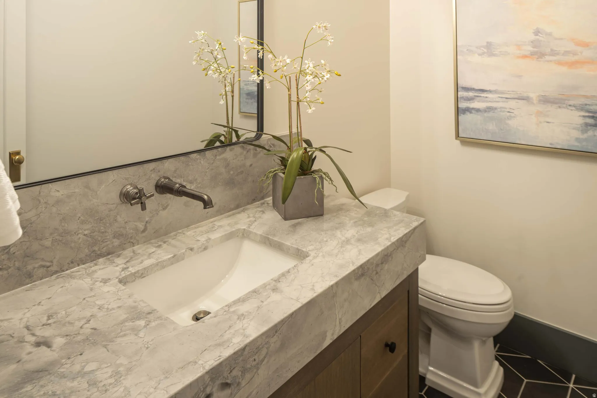 Vanity featuring a stone countertop and backsplash, undermount sink, and wall-mounted faucet