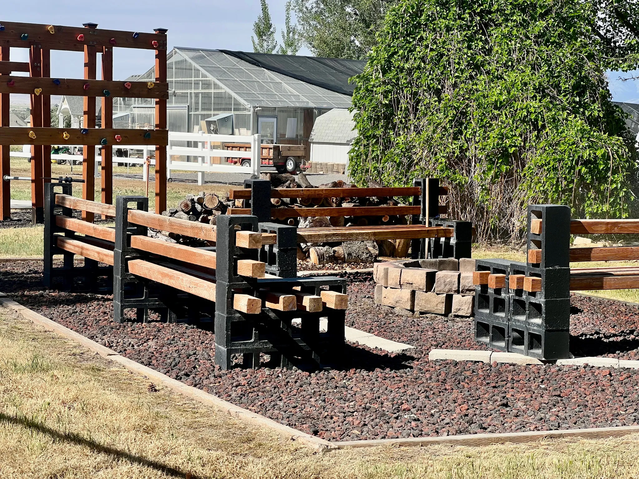 Outdoor gathering space featuring a stone-lined fire pit, surrounded by wood and concrete block benches
