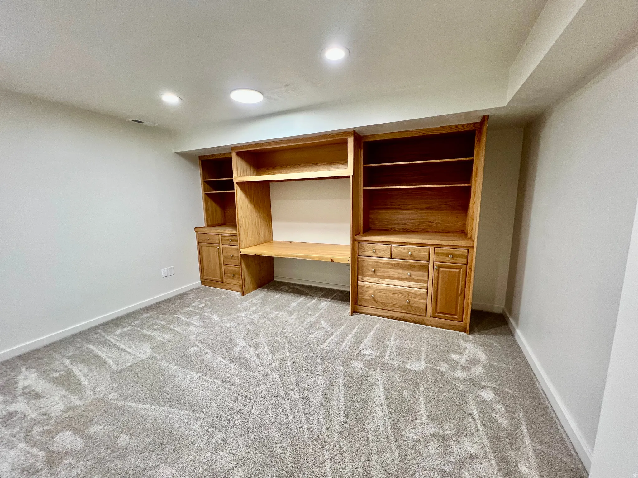 Built-in wood cabinetry with integrated desk space, shelving, and drawers