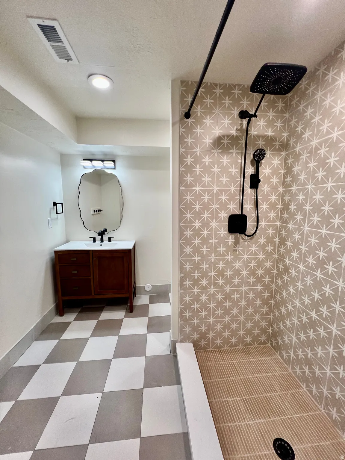 Bathroom featuring a walk-in shower with patterned tile surround and an integrated rain showerhead