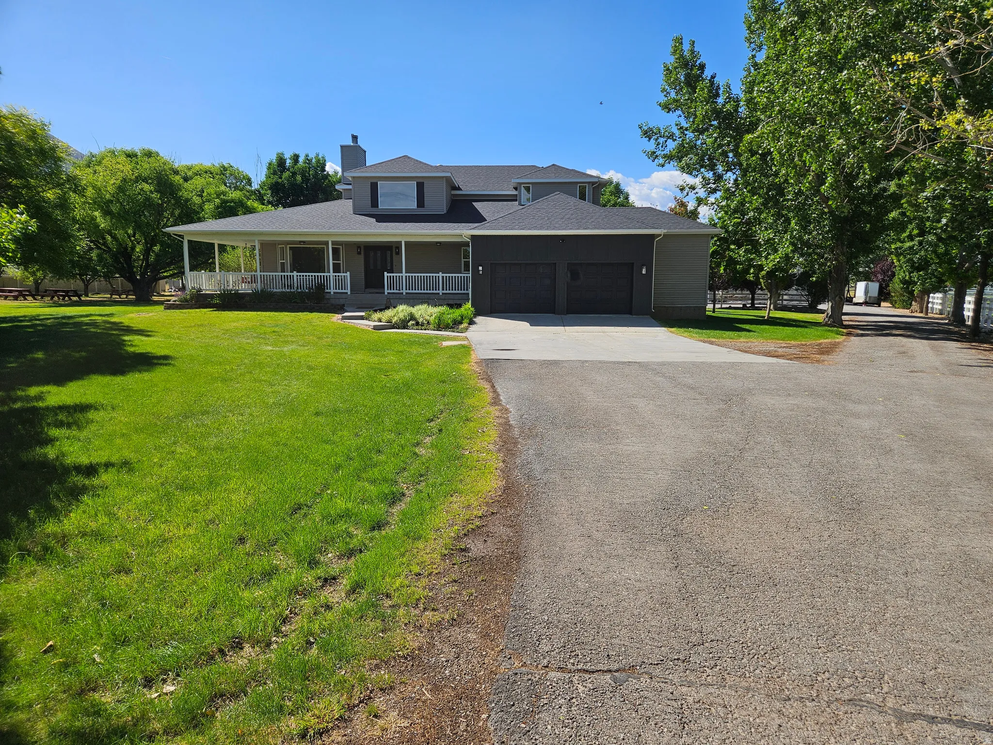 Contemporary residence featuring a wraparound covered porch and a two-car garage