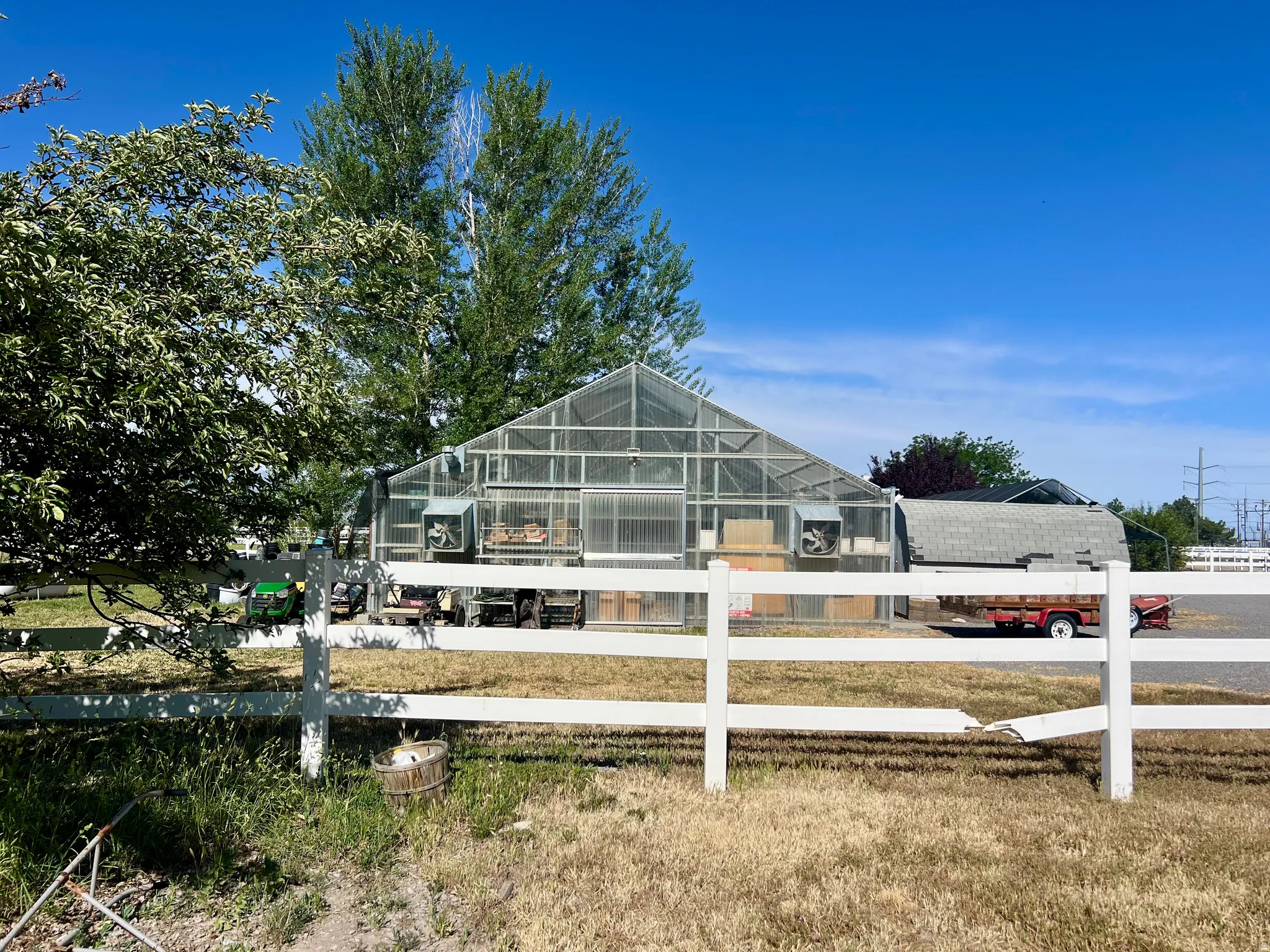 Large-scale greenhouse structure featuring transparent paneling and integrated ventilation systems