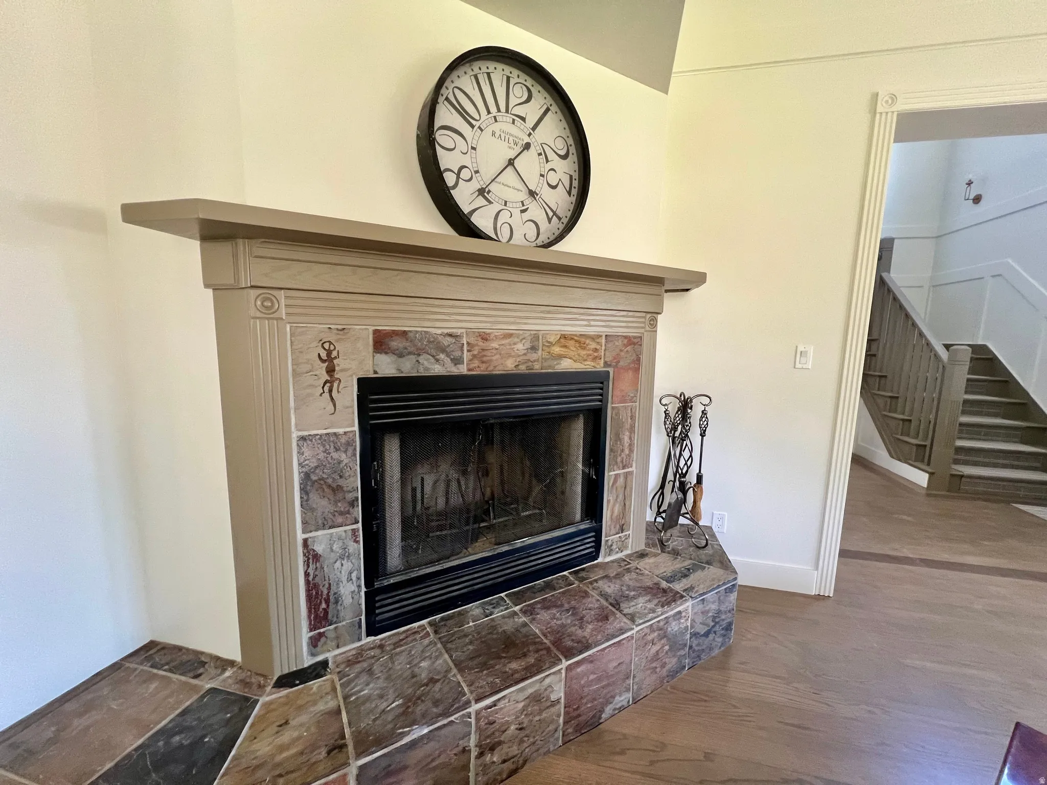 Fireplace with a decorative mantel and a stone tile surround, complemented by a matching stone hearth