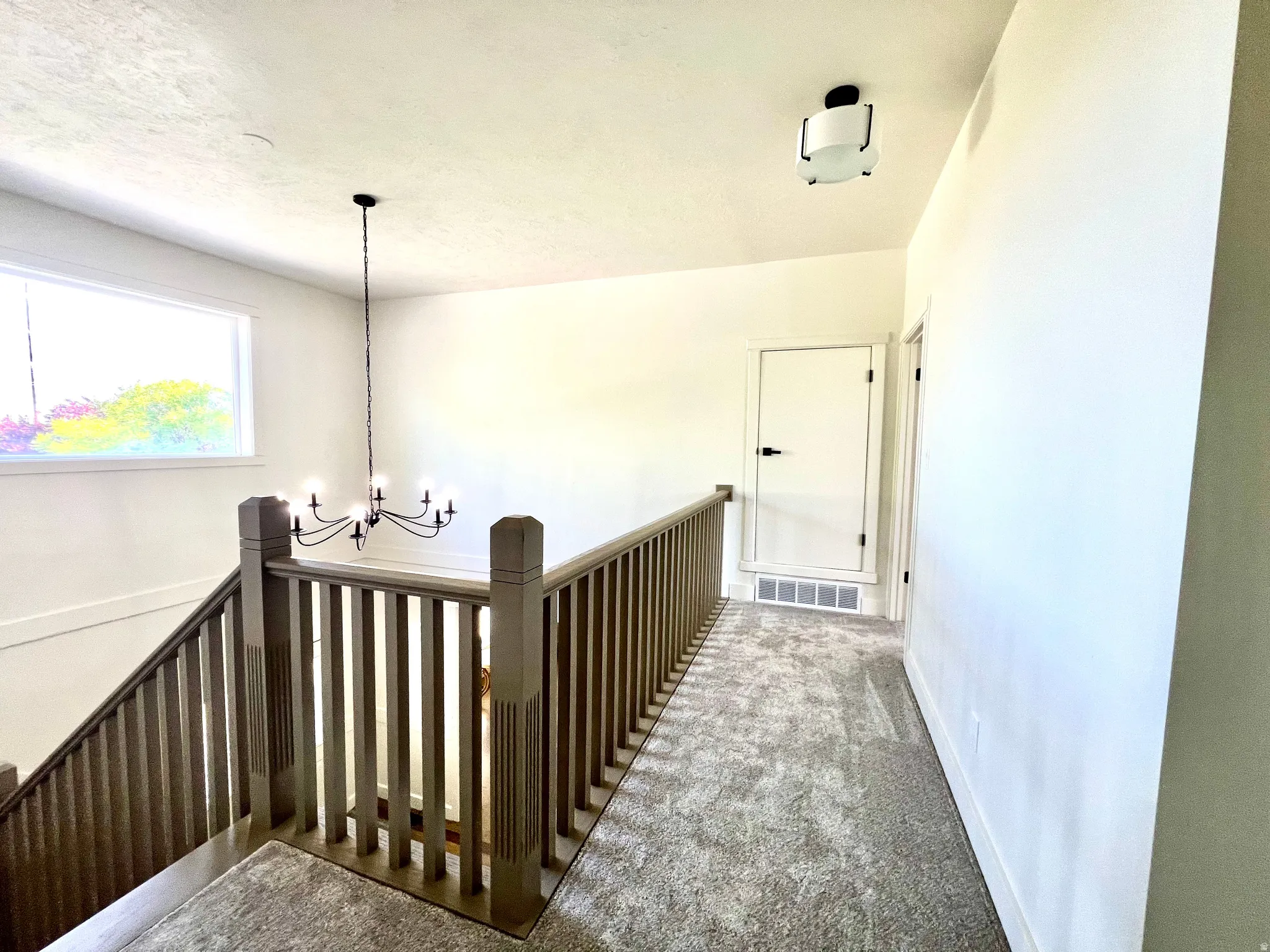 Upper landing featuring carpet flooring and white walls