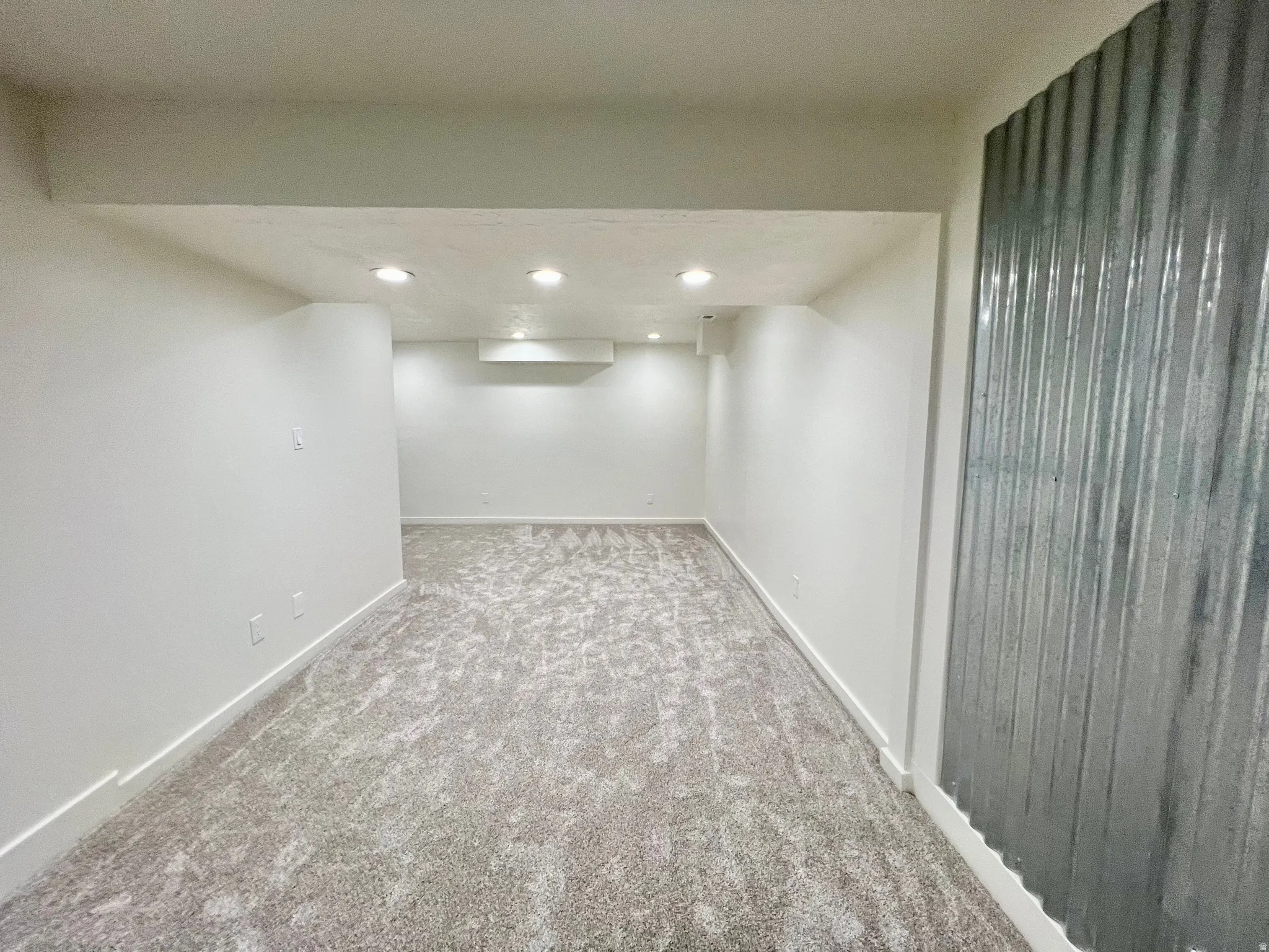 Spacious room featuring new carpet flooring and recessed lighting