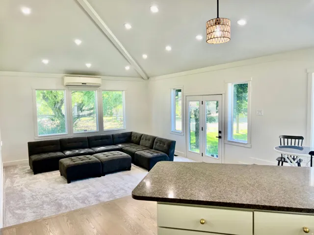 Vaulted ceiling with recessed lighting and a decorative pendant fixture