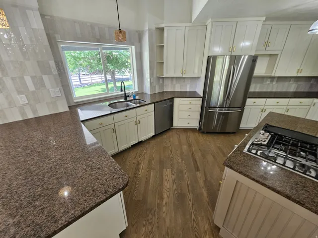 Kitchen featuring wood-finish flooring and light-toned cabinetry