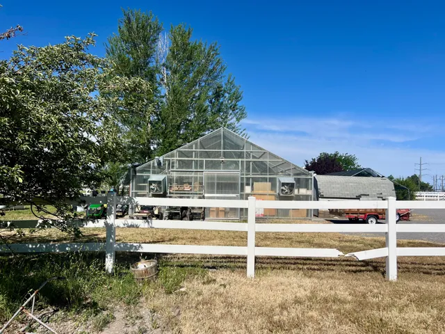 Large-scale greenhouse structure featuring transparent paneling and integrated ventilation systems