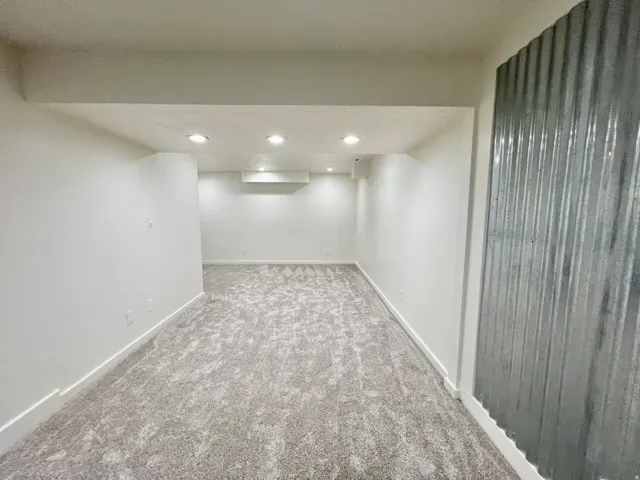 Spacious room featuring new carpet flooring and recessed lighting