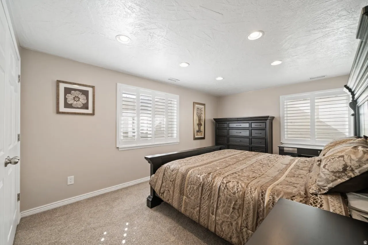 Bedroom featuring light colored carpet, recessed lighting, and a textured ceiling