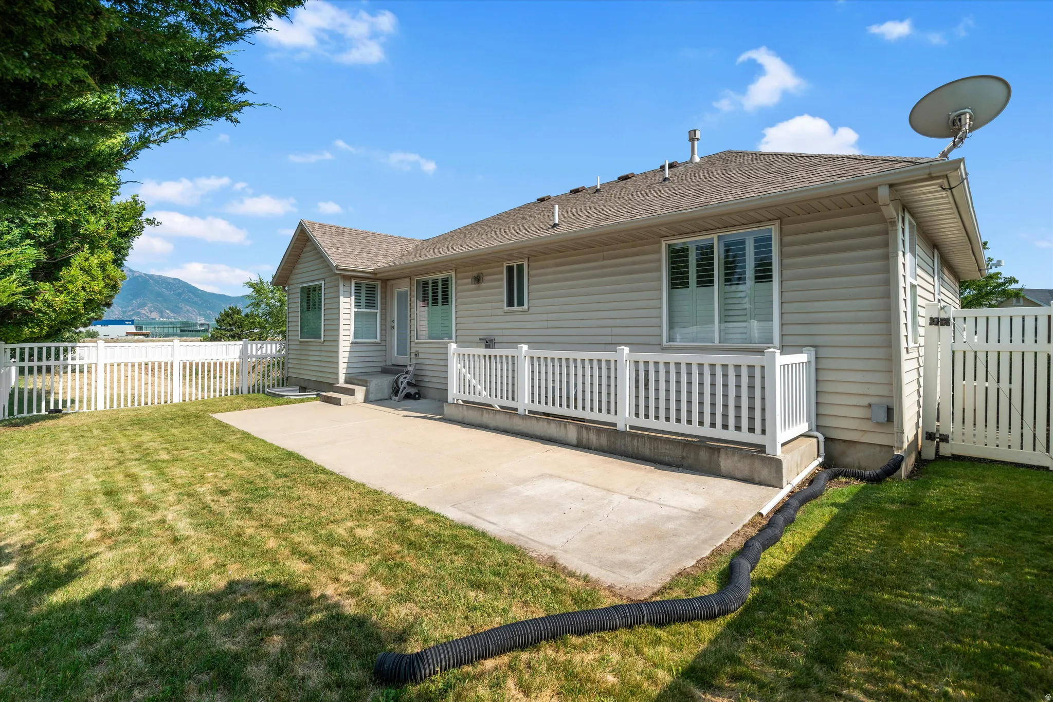 Expansive concrete patio with white picket fencing surrounding the perimeter