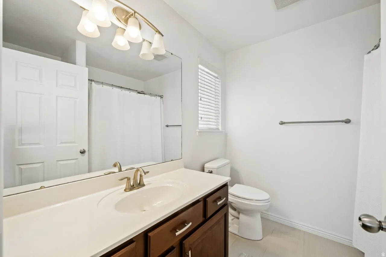 Bathroom featuring vanity, a shower with curtain, and light tile patterned flooring