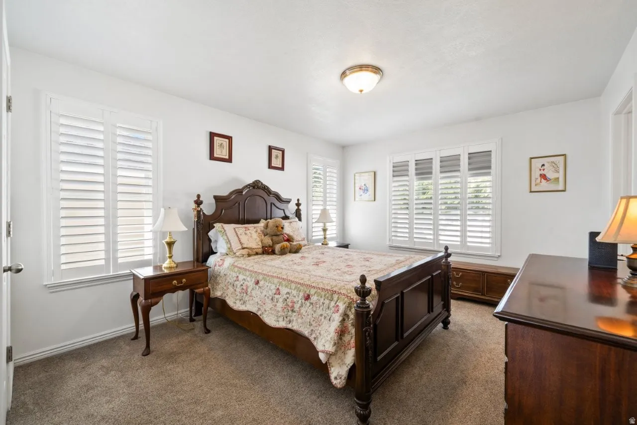 Bedroom featuring dark carpet and baseboards