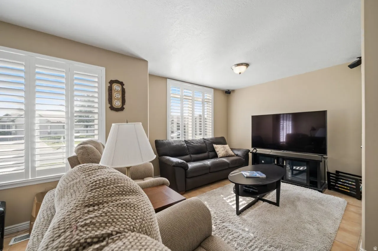 Living room with a textured ceiling and light wood-style flooring