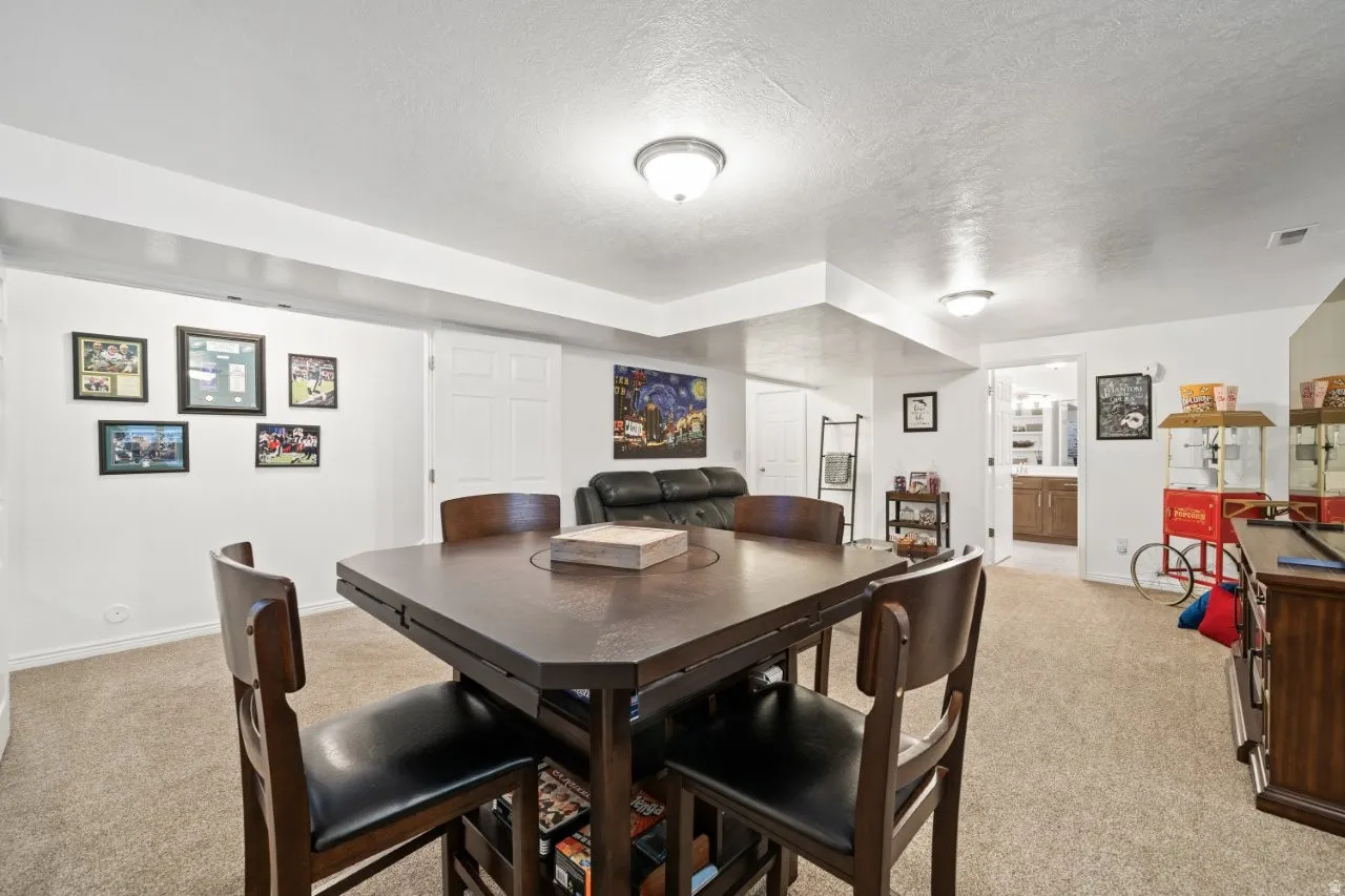 Dining room with a textured ceiling and light carpet