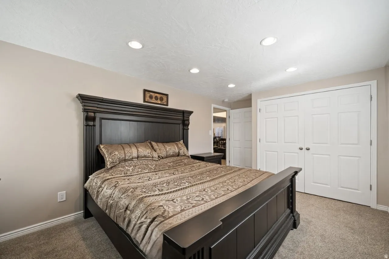 Bedroom featuring recessed lighting, light colored carpet, a closet, and a textured ceiling