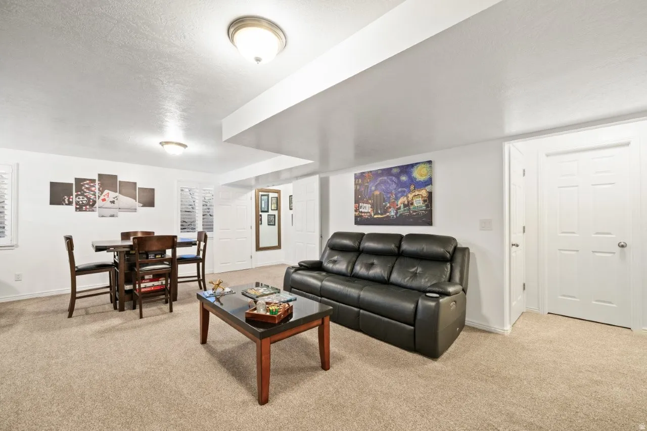 Living area with light colored carpet and a textured ceiling