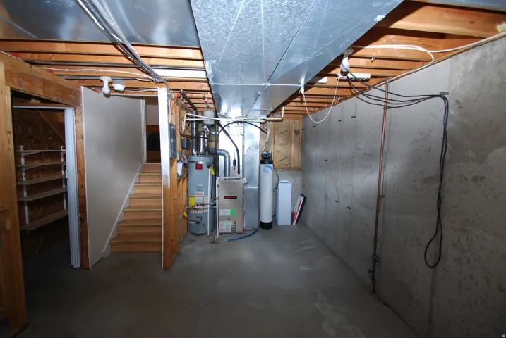 Unfinished basement with concrete flooring and exposed ceiling joists