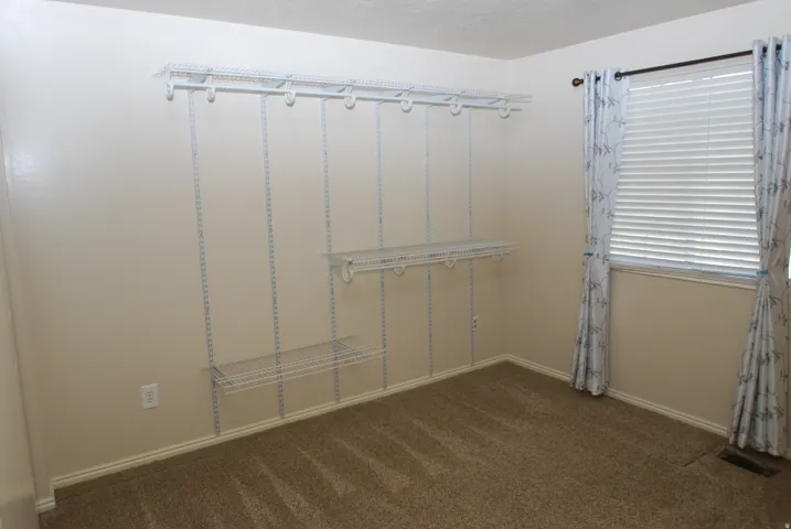 Room with neutral wall paint and brown carpet flooring