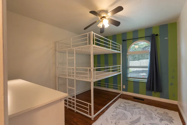 Windowed room featuring wood-finish flooring and a ceiling fan
