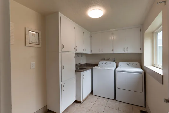 Utility laundry room with sink, natural light and easy access ! Perfect for animals, lots of storage !