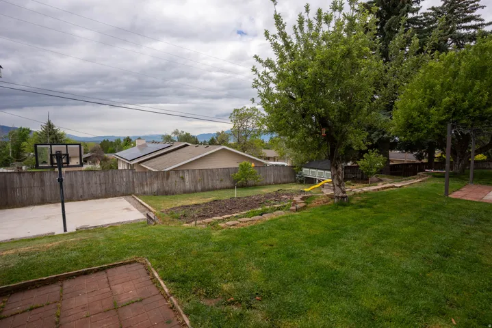 Lots of play space in this back yard!  A court, garden, fruit trees, and berries !  Check out the views !