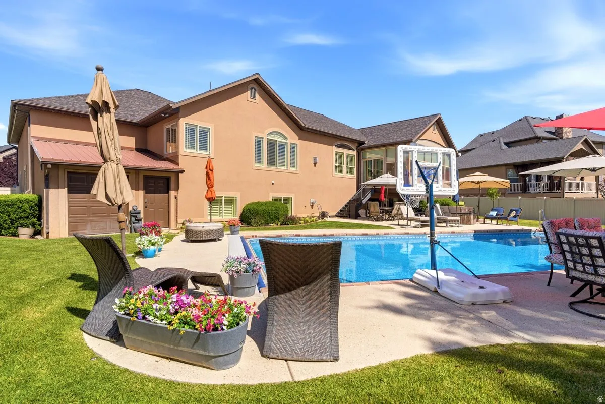 Expansive backyard featuring a large in-ground swimming pool, a dedicated patio area, and a lush lawn