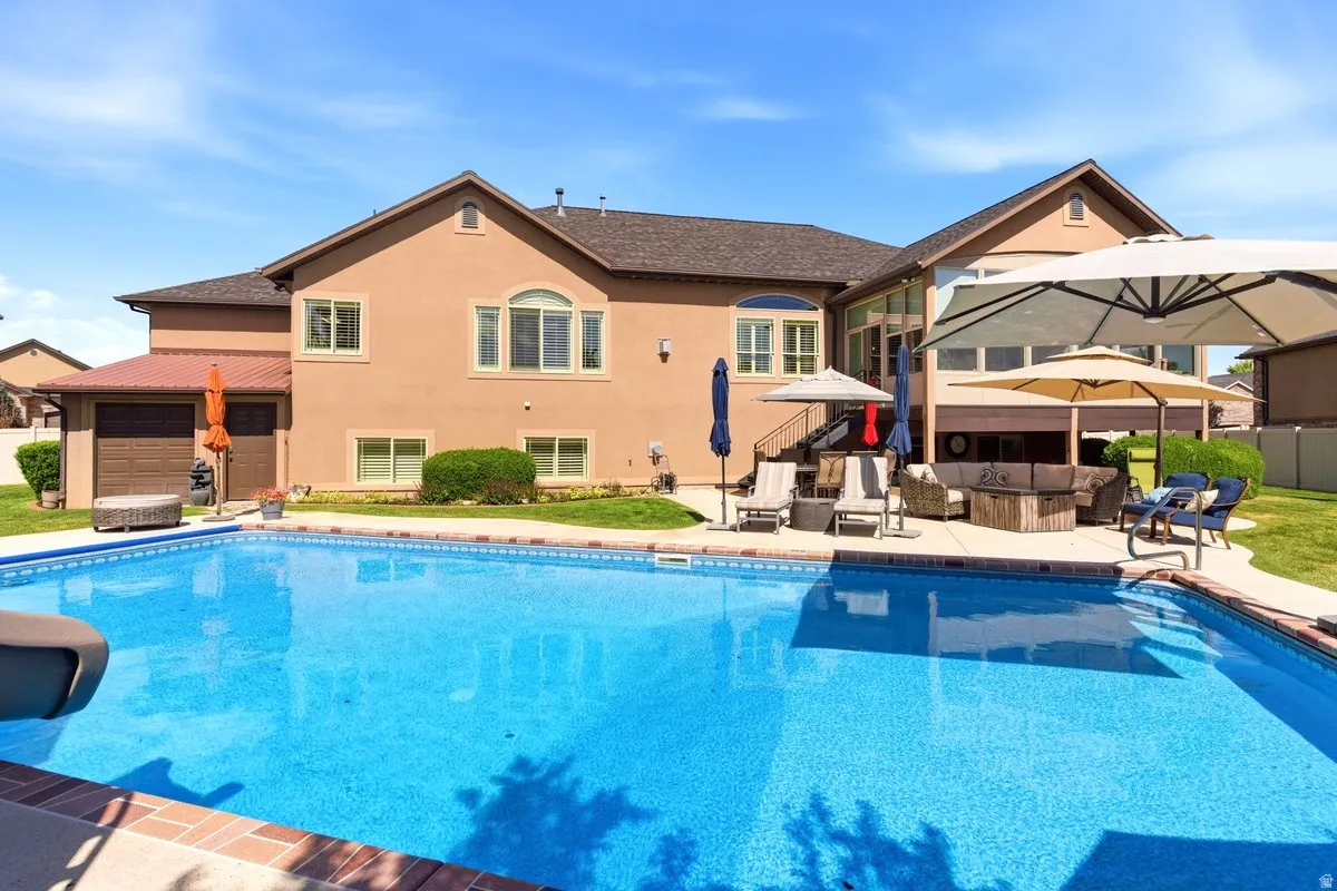 Expansive swimming pool with integrated slide, complemented by an adjacent hardscape patio
