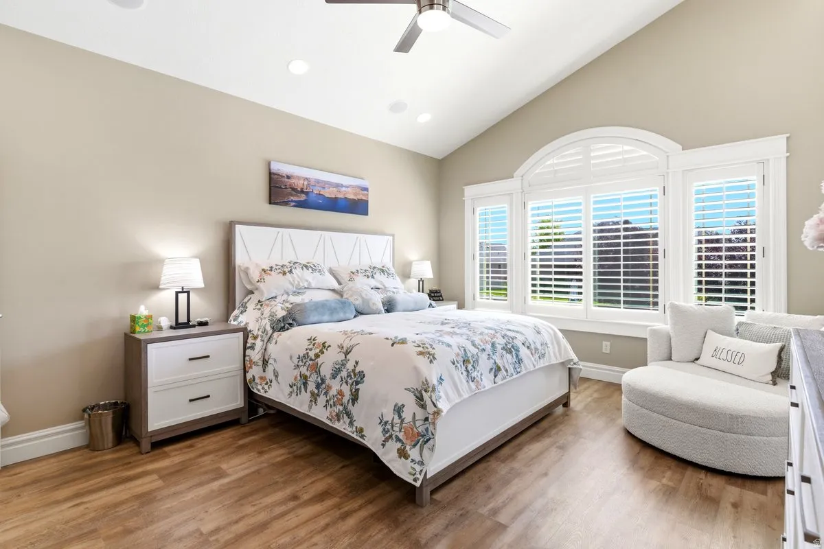 Vaulted ceiling bedroom with wood-finish flooring