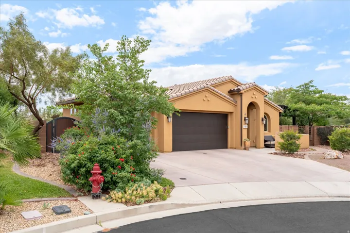 Stucco exterior with a tile roof, an arched entryway, and a 3 car integrated garage