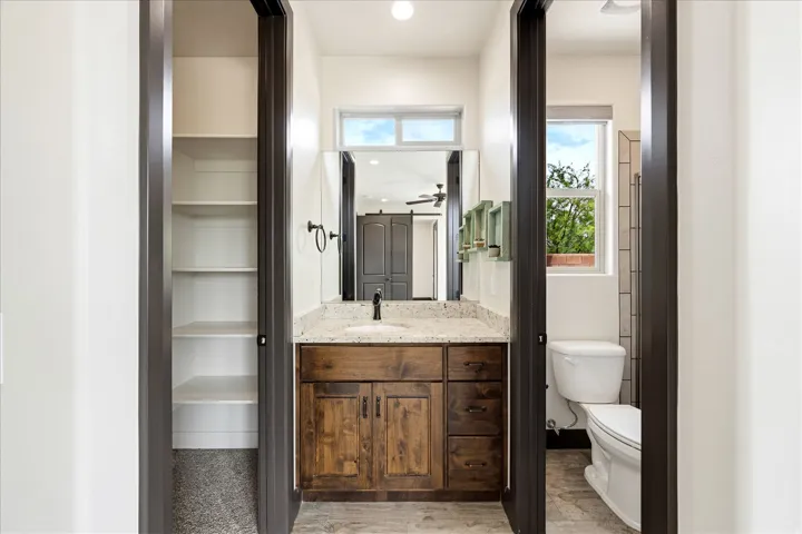 Bathroom featuring a rustic wood vanity with a granite countertop, a rectangular undermount sink, and a matte black faucet