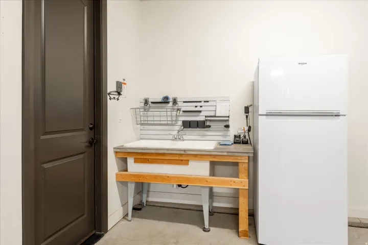 Utility sink with a gray countertop and wall-mounted organization system