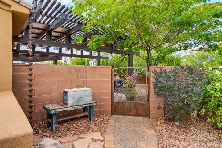 Architectural pergola with a decorative rain chain and stucco exterior