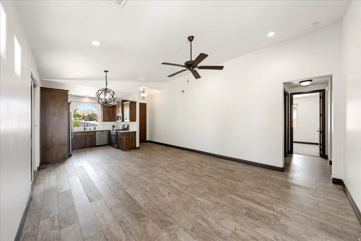 Open-concept living space featuring wood-finish flooring, vaulted ceilings, and recessed lighting