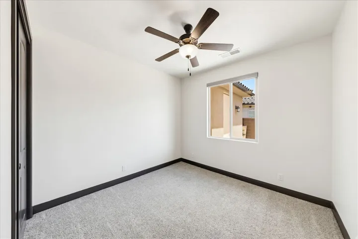 Room featuring light gray carpet, white walls, and dark baseboards