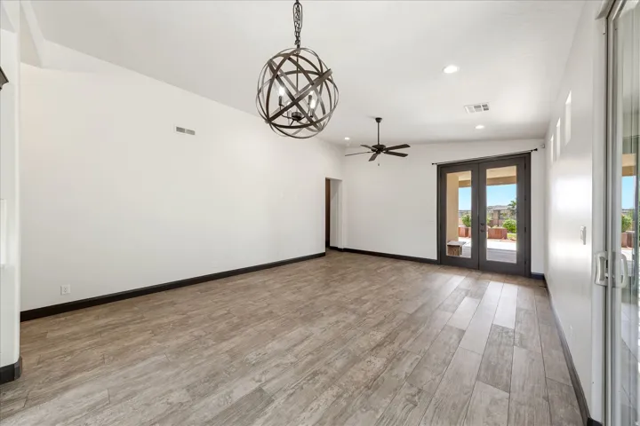 Spacious room featuring wood-finish flooring, a contemporary spherical chandelier, recessed lighting, and a ceiling fan