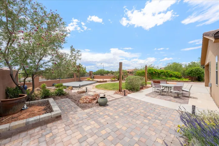 Expansive outdoor living area featuring multi-toned paver stone and concrete patios