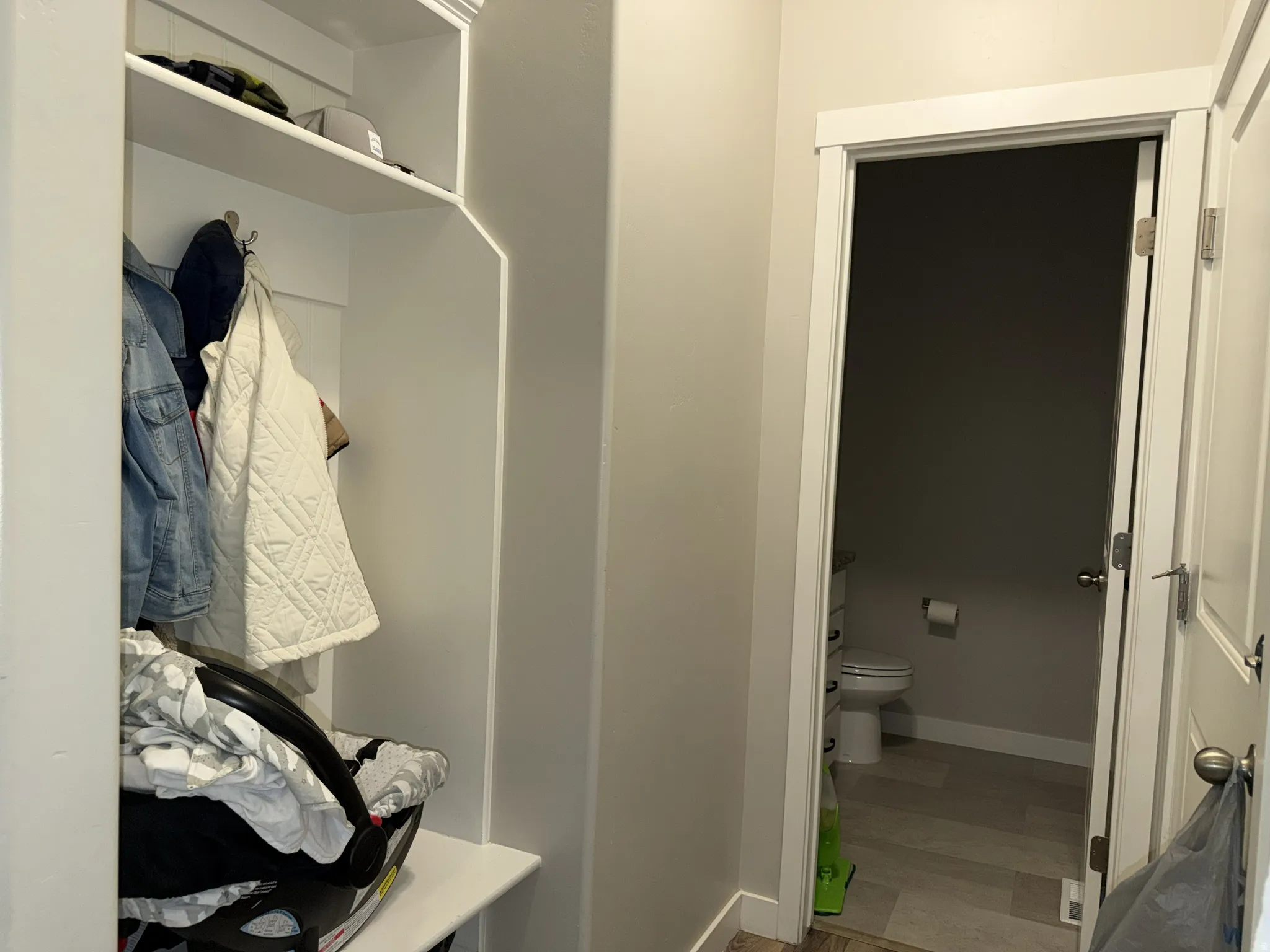 Built-in mudroom storage with coat hooks and an upper shelf