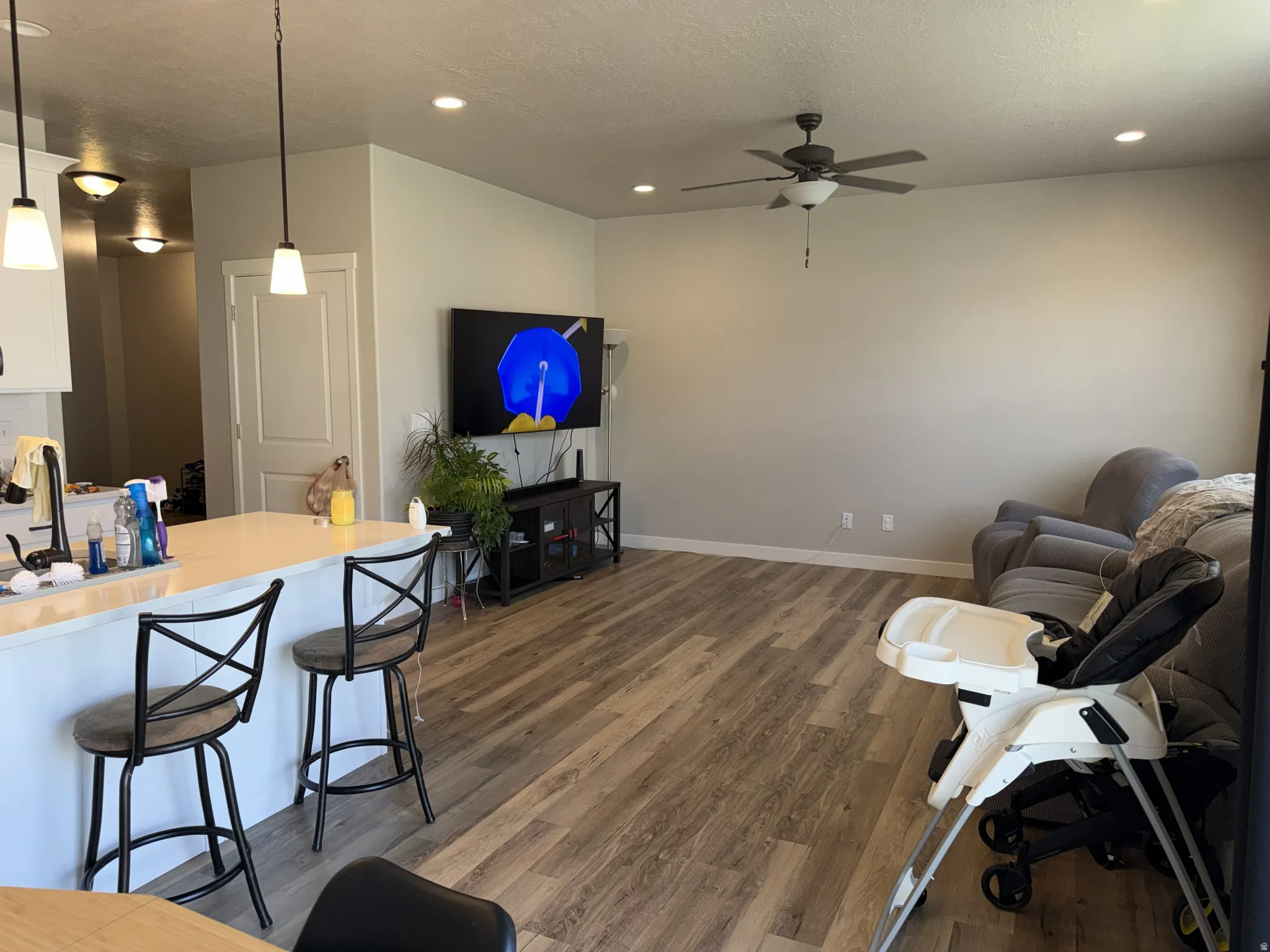 Open-concept living space featuring wood-finish flooring, recessed lighting, and a ceiling fan