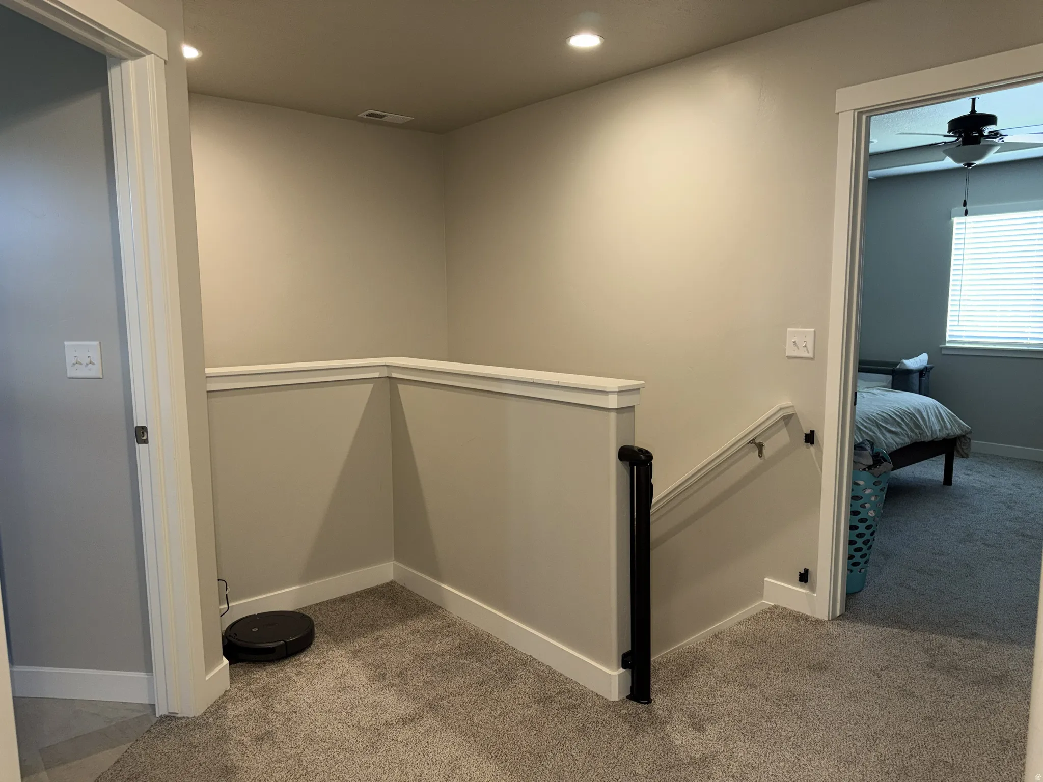 Upper-level hallway featuring neutral-toned walls, recessed lighting, and soft carpet flooring