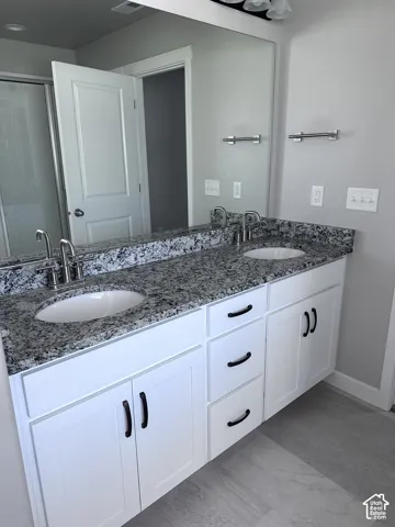 Double vanity featuring granite countertops with undermount sinks and brushed nickel faucets
