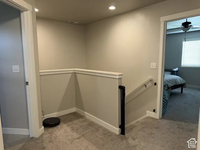 Upper-level hallway featuring neutral-toned walls, recessed lighting, and soft carpet flooring