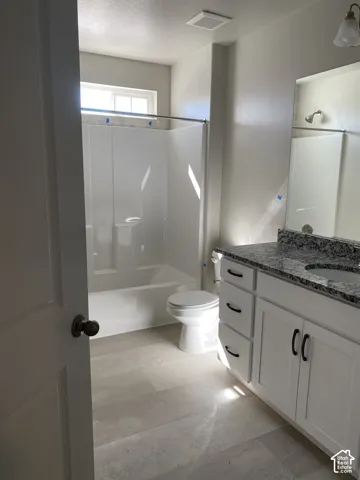 Bathroom featuring a white vanity with dark hardware, a granite countertop, and an integrated sink