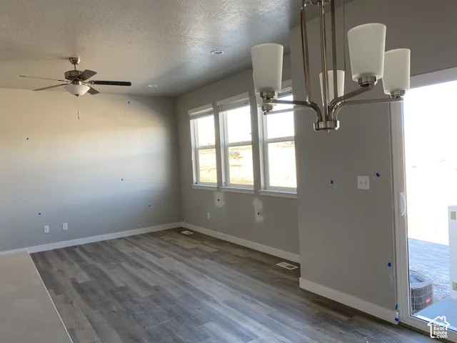 Spacious interior with wood-finish flooring, recessed lighting, and a contemporary ceiling fan