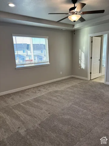 Spacious room featuring neutral carpeting, a ceiling fan with integrated lighting, and recessed ceiling lights