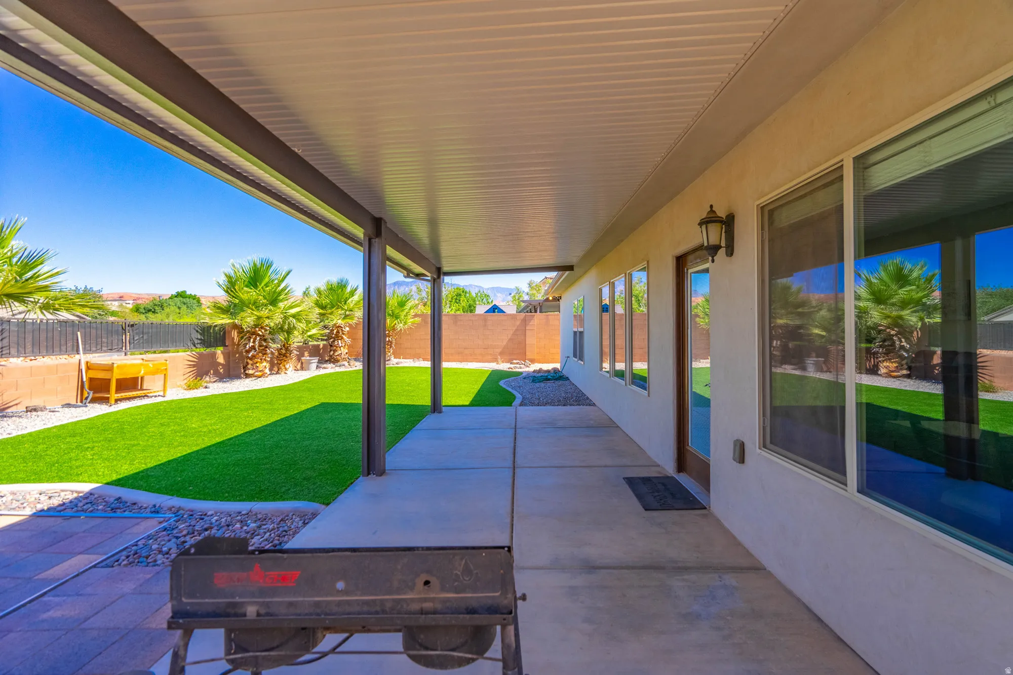 Covered patio featuring a concrete surface, multiple windows, and a glass-paneled door
